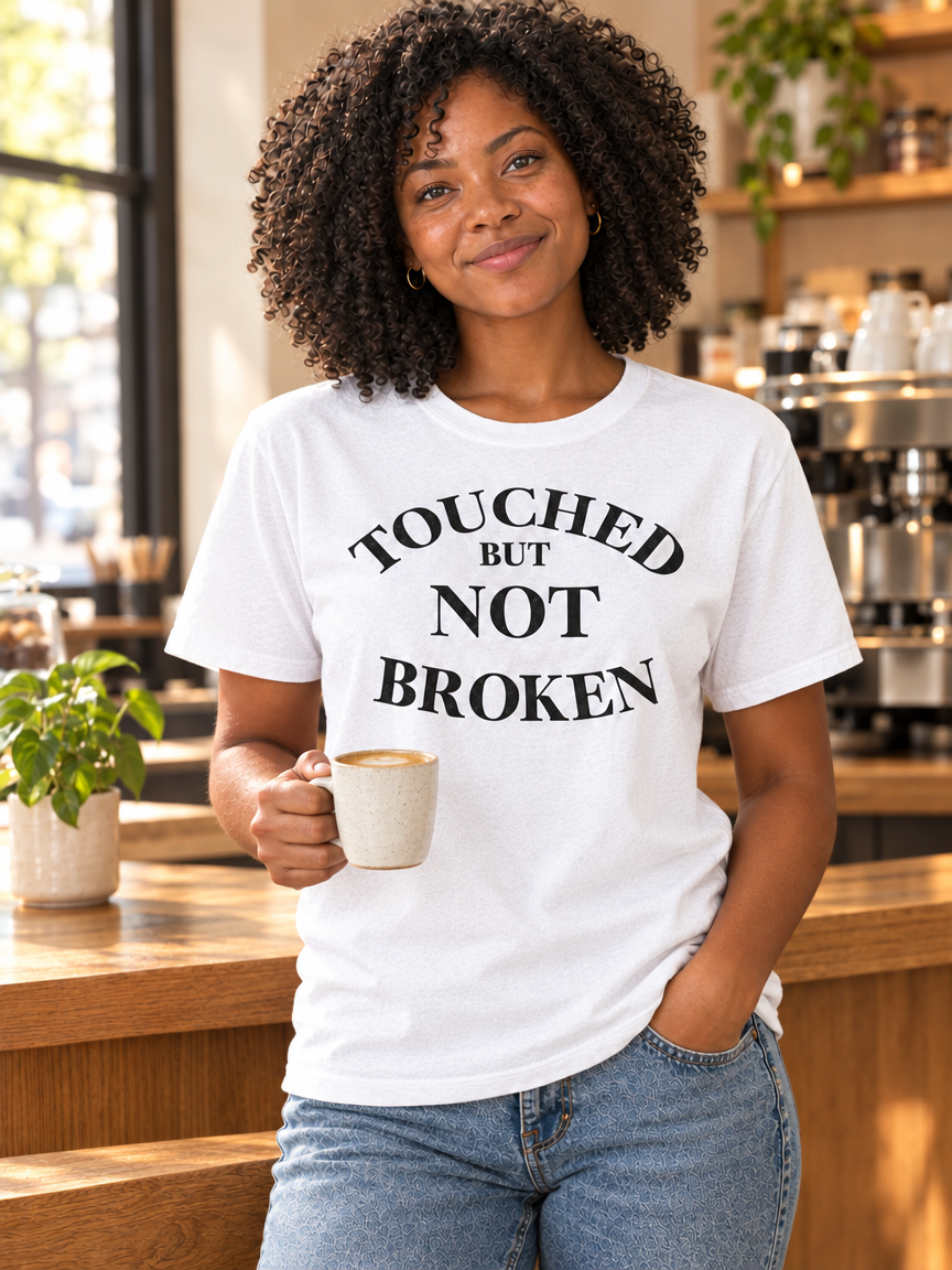 Touched But Not Broken Tee, white cotton T-shirt with bold black serif lettering across the chest.